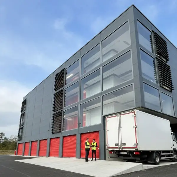 centre annexx avec un camion au quai de déchargement et 2 personnes qui discutent